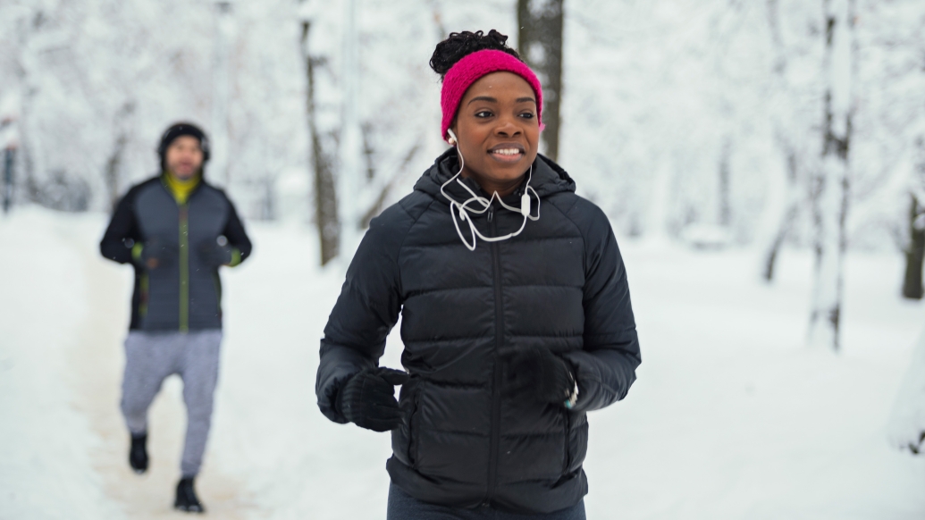 Man and women jogging ear buds on