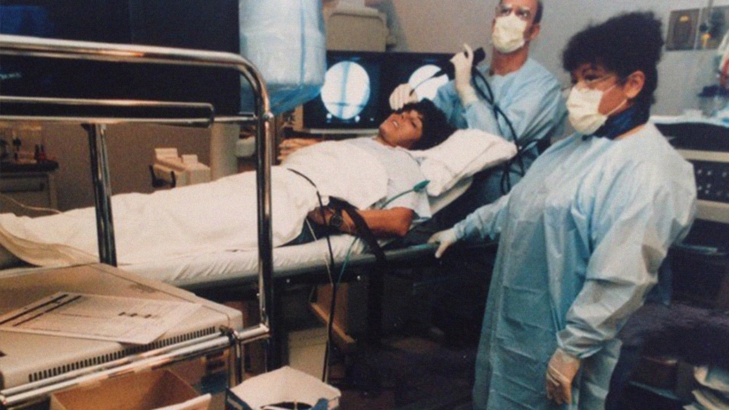 woman on hospital bed with two nurses with masks and blue gown