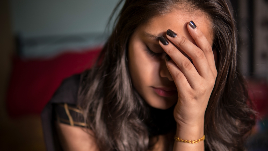 Sad young woman face in hand