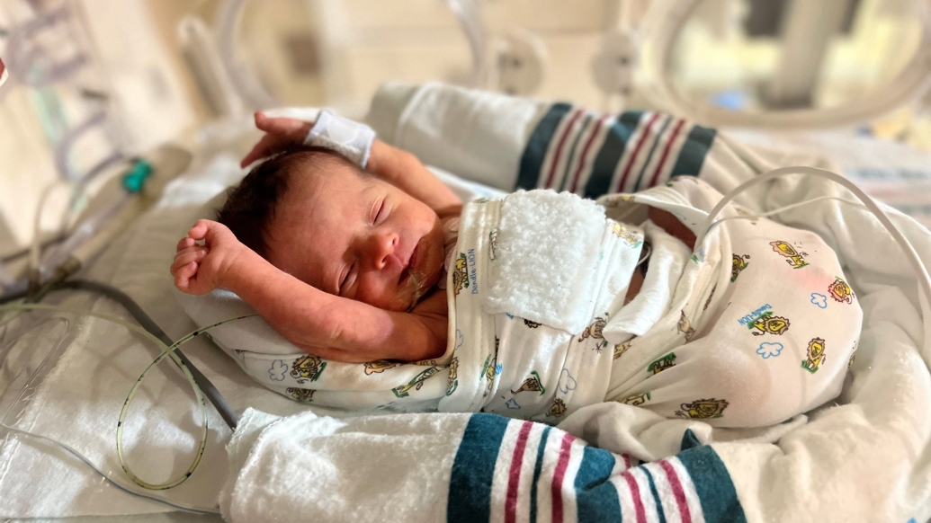 baby stretching in hospital bed