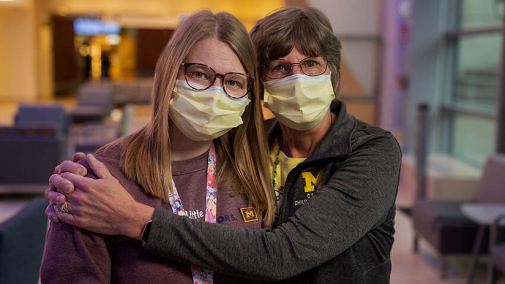 Mother and daughter nurses hugging in room at Mott.