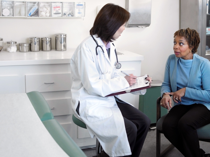 doctor talking to patient in clinic with blue shirt