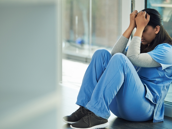 woman doctor scrubs sad ashamed lab note