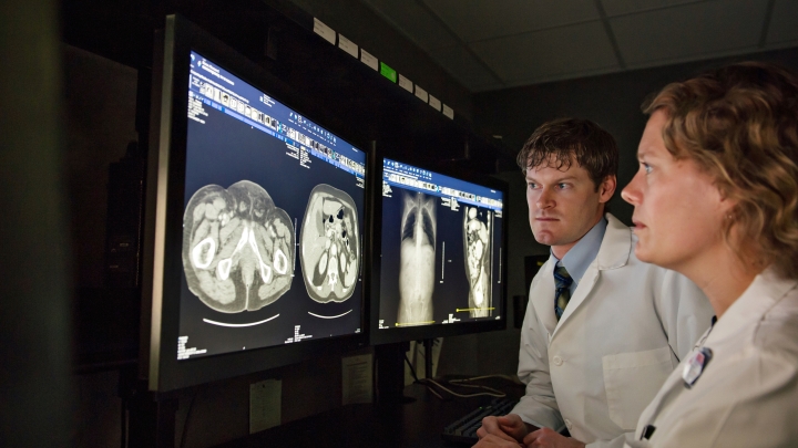 Young female and male doctors looking seriously at radiology images