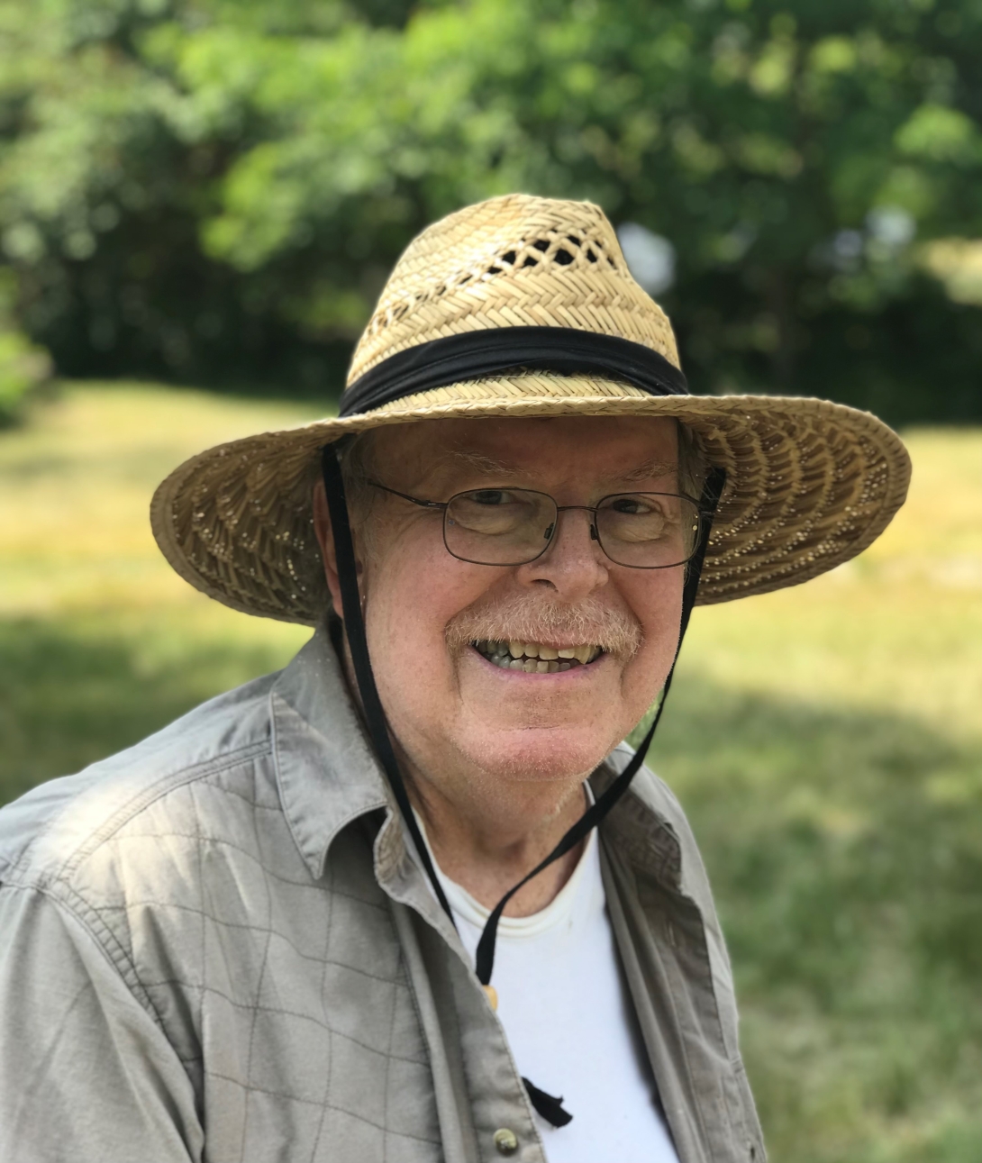 man smiling at camera with hat