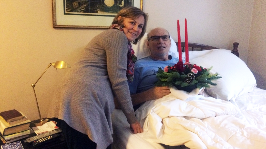 Patient in hospital bed smiling holding flowers