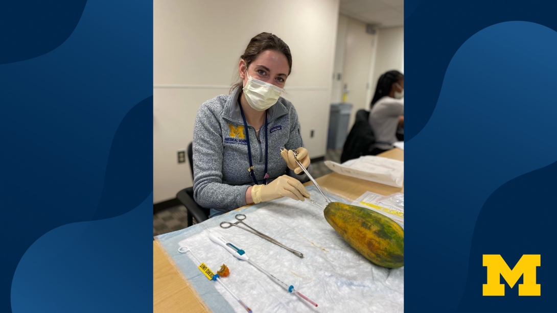 doctor sitting at table with sutures mask on smiling