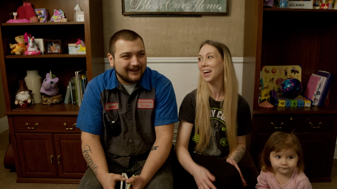 parents laughing together sitting with kid next to them