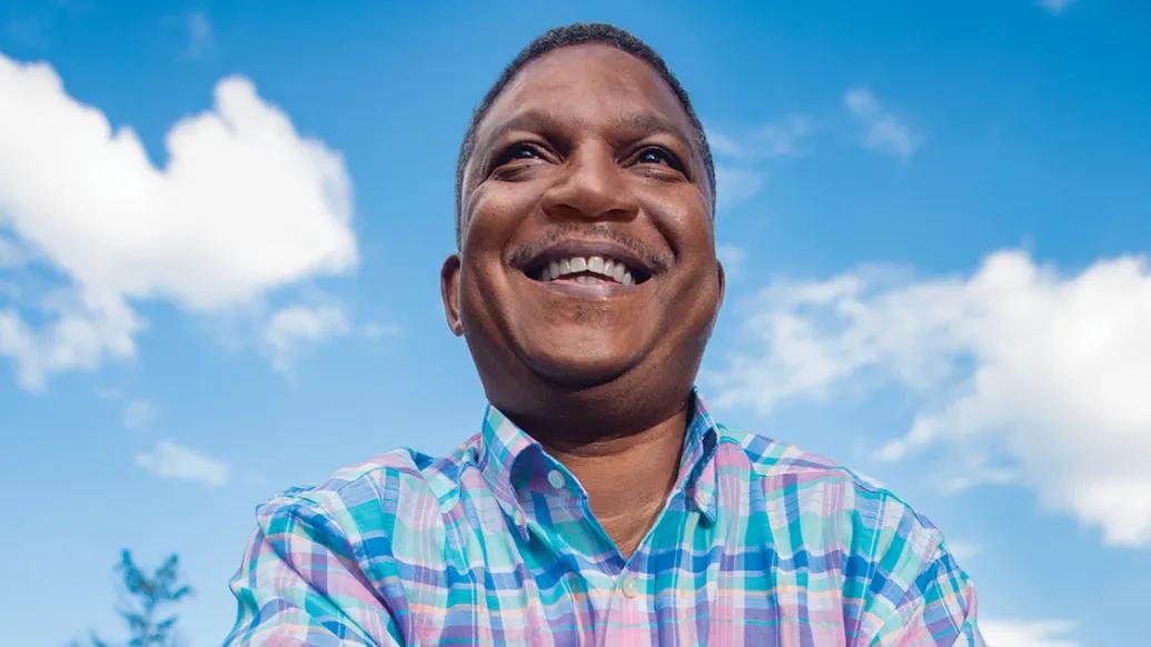Andre smiles with the blue sky behind him