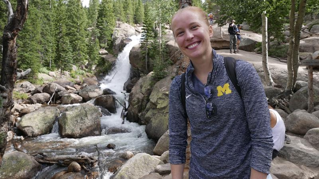 Julie on a hiking trip posing by a waterfall