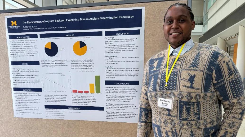 A man stands next to a research poster