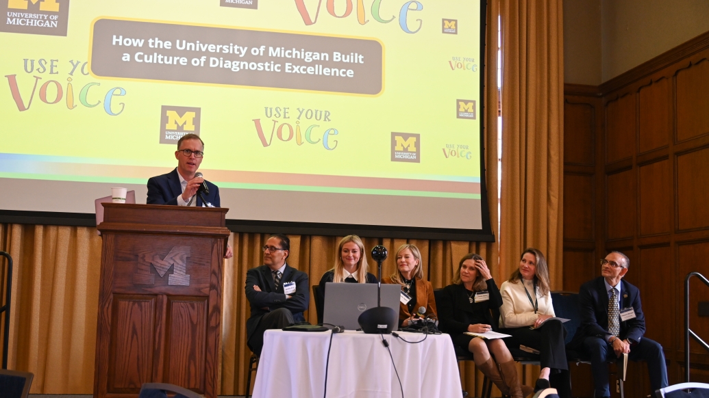 A panel sits on stage and speak
