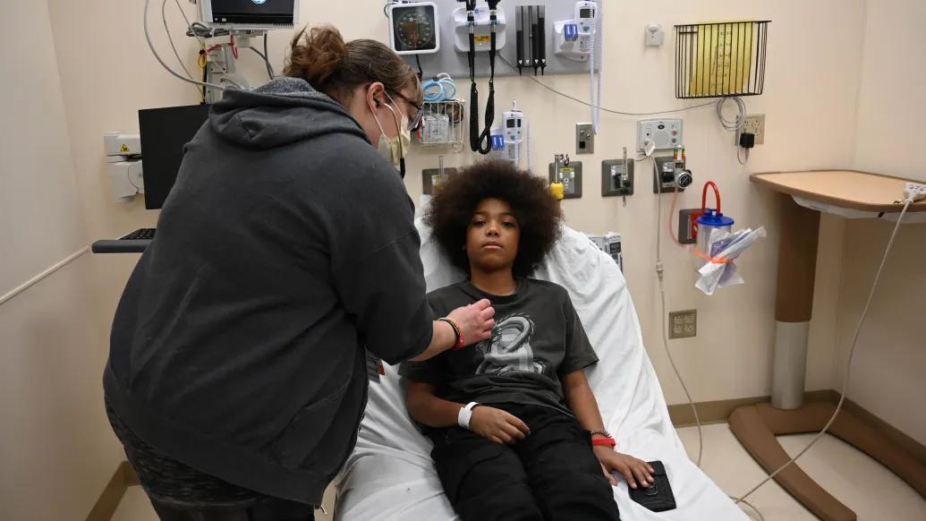 A PA listens to a patients heart