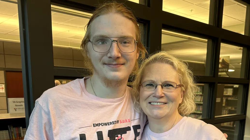 man and woman standing together in pink shirts