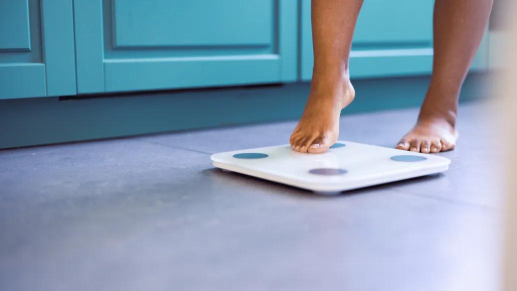 person stepping one foot onto scale
