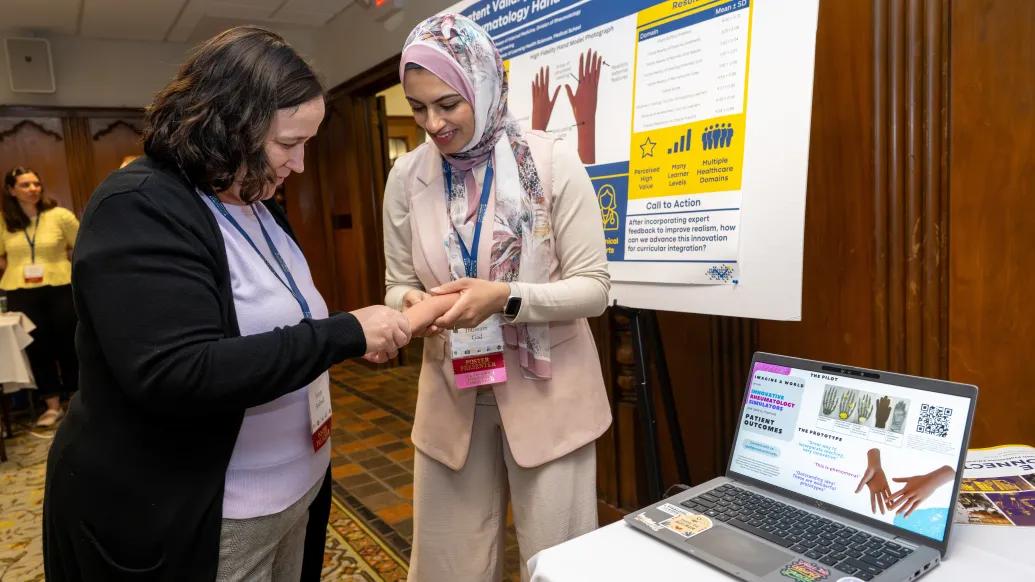 Ibtissam Gad performs a demo of her hand model with an HPE Connect '26 attendee.