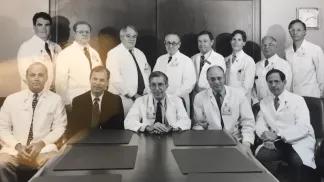Black and white photo of Department of Surgery team members in a conference room