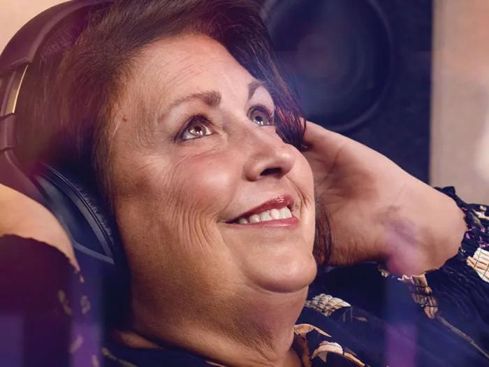 Sherry smiles while wearing headphones