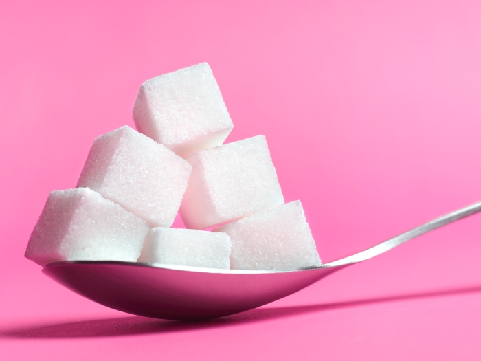 Sugar cubes on pink background