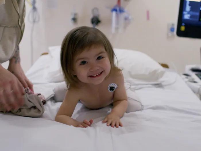 toddler laying on bed in hospital 