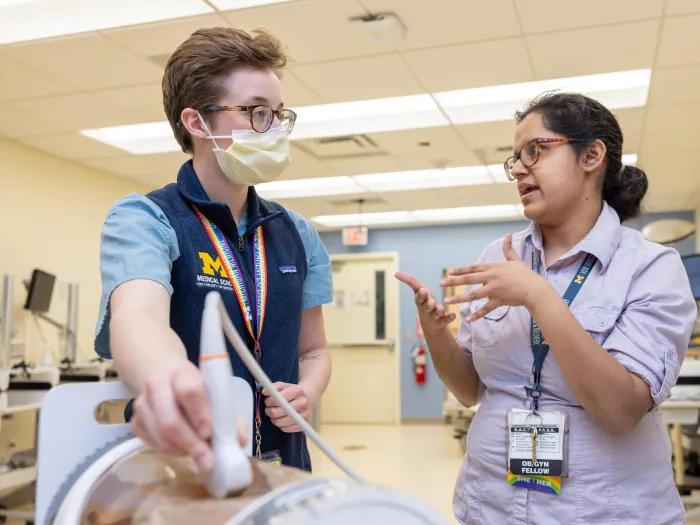  obgyn fellow talks to studuent during lab simulation 