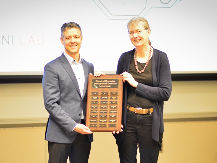 professor receiving distinguished leadership award from another colleague 
