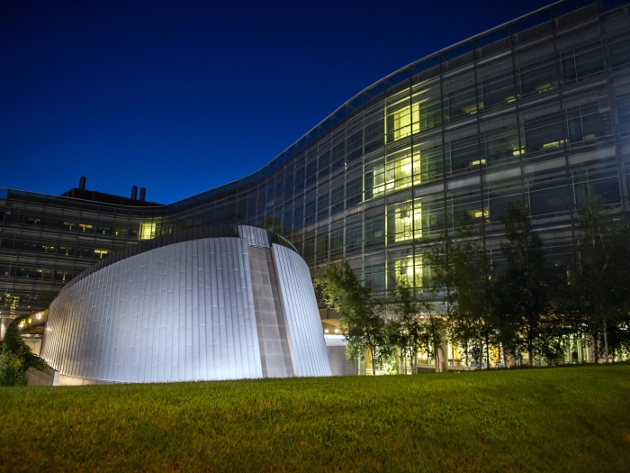 biological sciences research building at night with lights on inside of building 