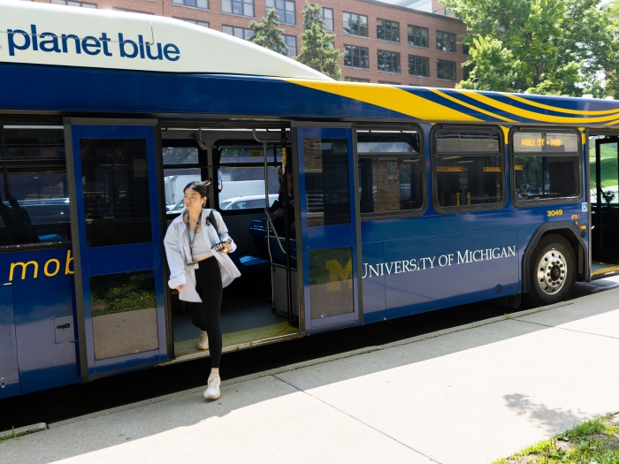 Woman exiting a blue bus