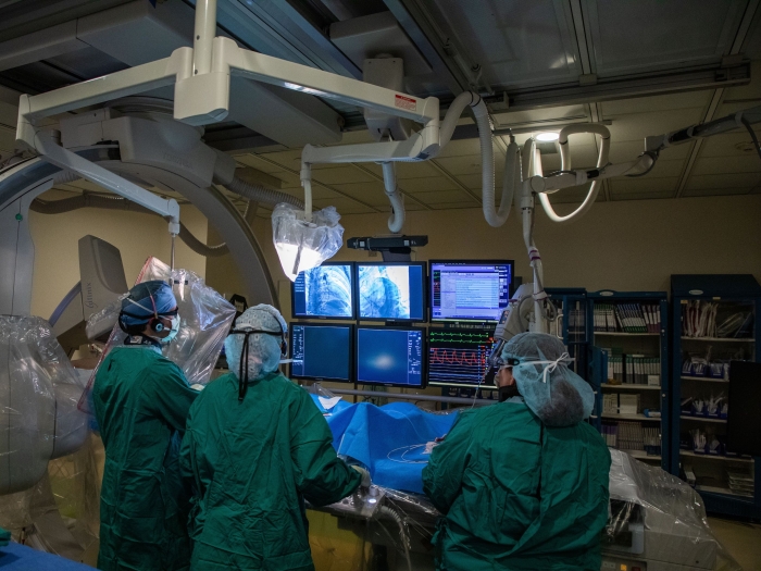 Pediatric Cardiology Catheter Lab with three clinicians working on a patient on and viewing images on digital screens