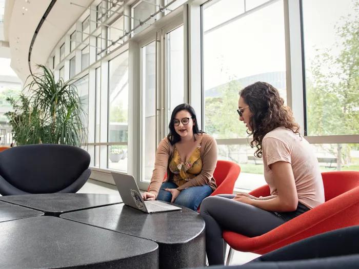 Two people working at a laptop in an open atrium