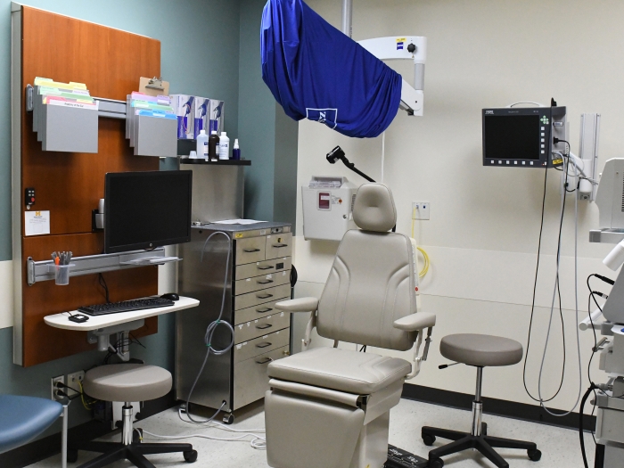  A medical room with a chair and a monitor