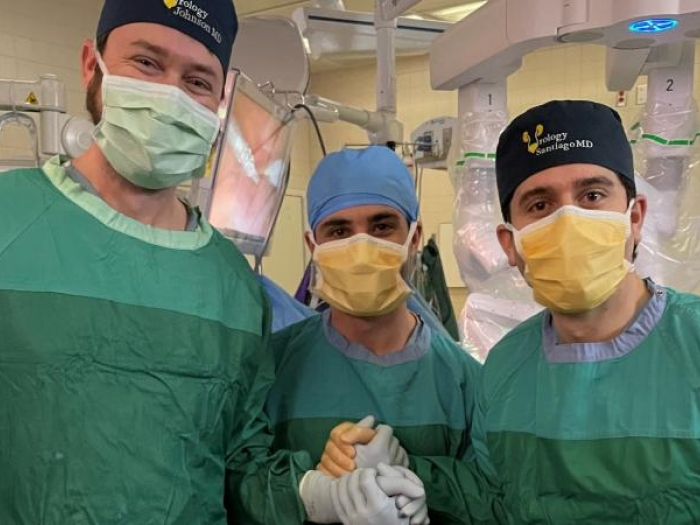 Three people in doctors masks in an operating room