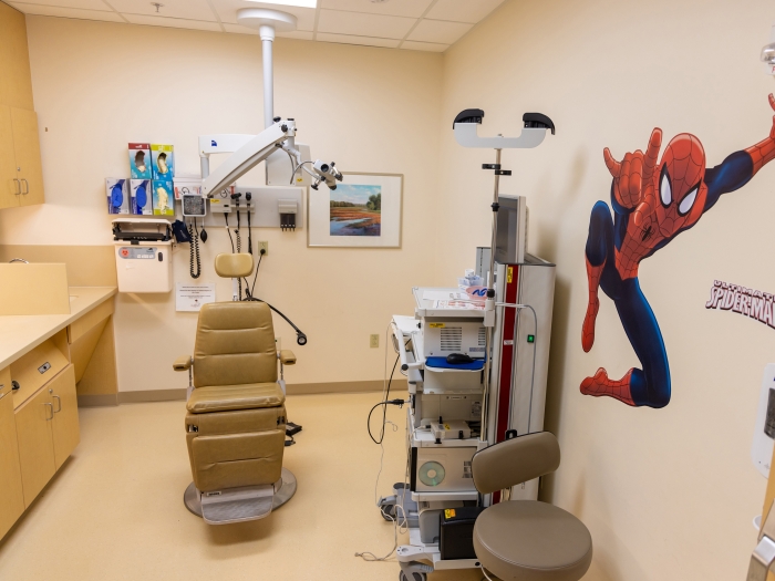 peds clinic room with a chair and a decal of spiderman