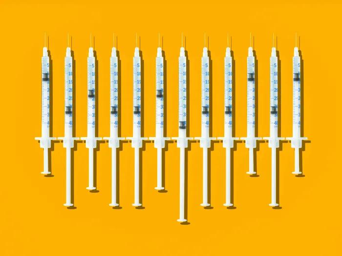 Syringes in a row on yellow backfround