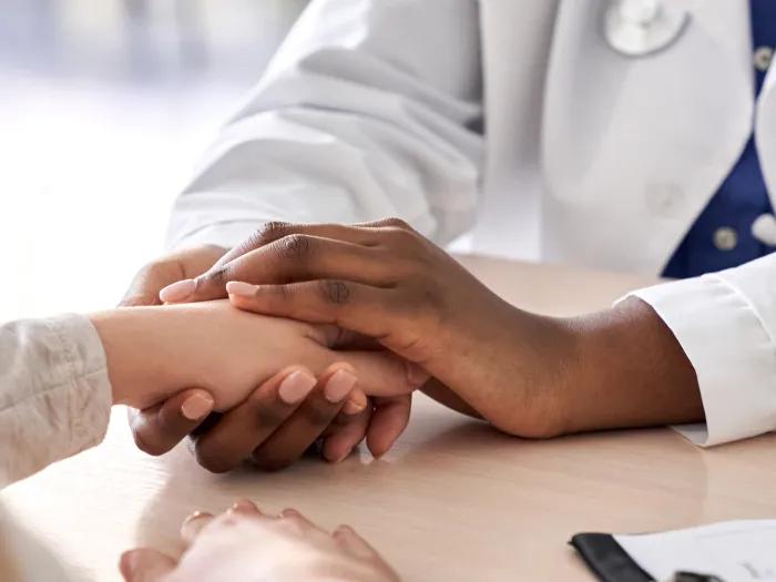 A doctor holding on to a person's hand