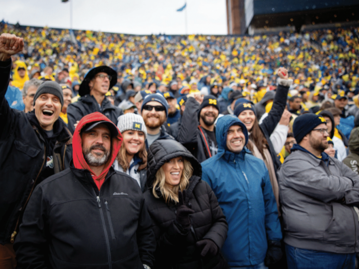 People cheer in the stands at a Michigan football game