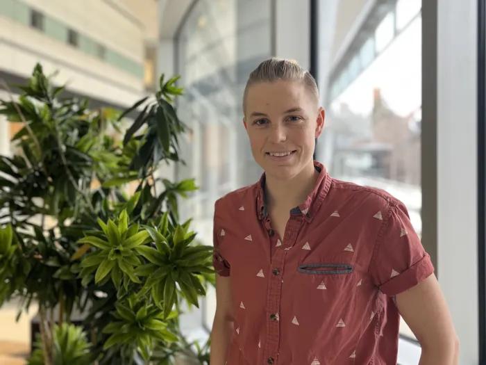 Katie Emery standing next to a plant