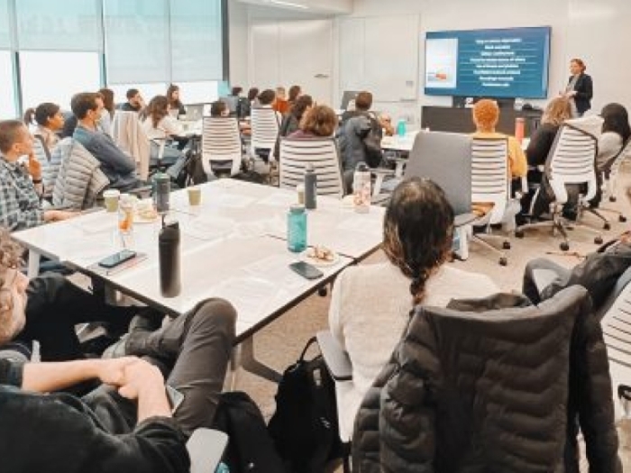 Group of people sitting at tables and watching someone present