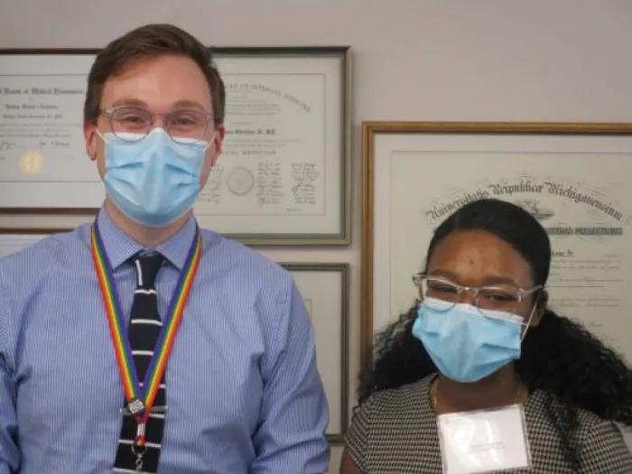 Two people in masks standing next to each other