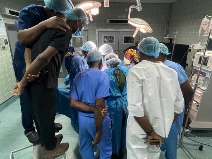 Medical team in scrubs surrounding a hospital bed, collaborating on treatment plan.