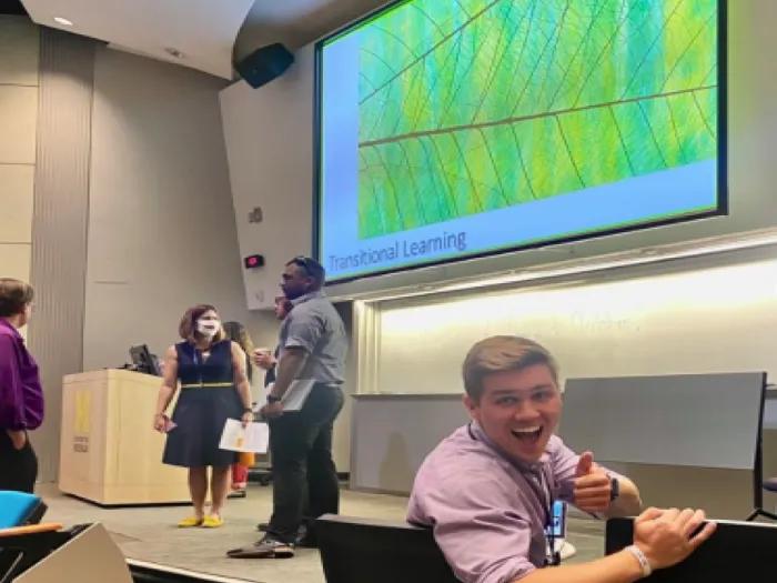 Some people in a room with a presentation screen in the background