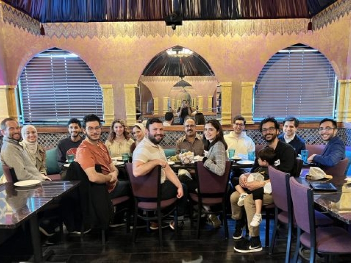 Group of people seated around a table facing the camera for a photo