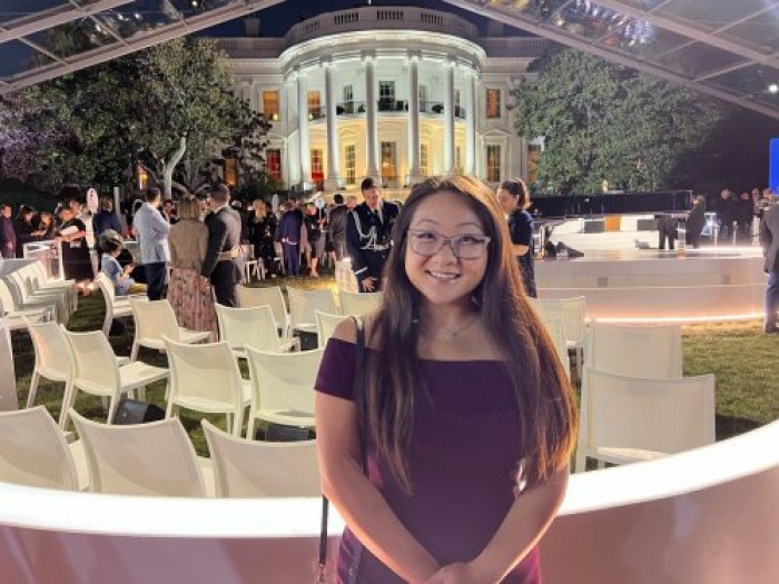 Woman standing on the White House lawn with chairs set up