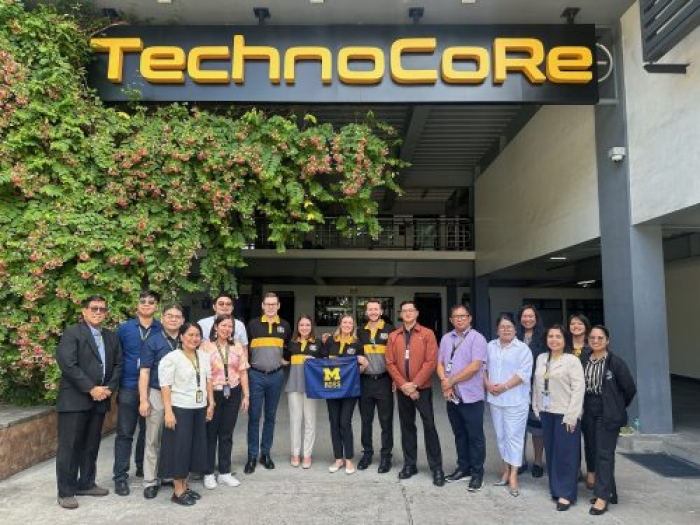 Group of people standing outside a building and underneath a sign that reads TechnoCore