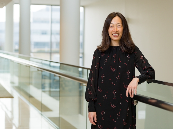 Grace Kim smiling for the camera standing in a hallway