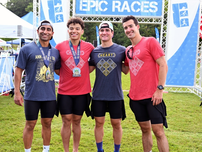 Four medical students display medals after a race, smiling arm in arm