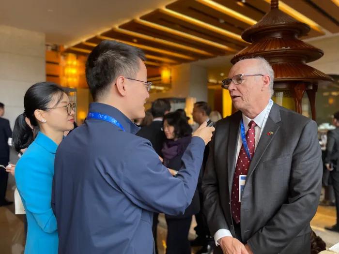 Three people in business wear talking to each other at a professional event