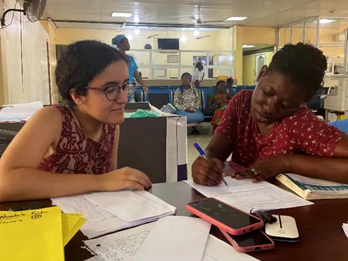 Two women sitting at table and looking over papers together
