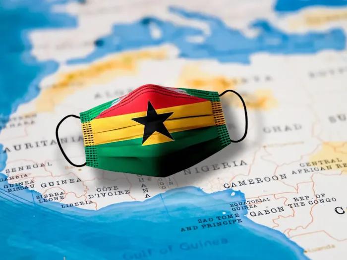 Graphic of a facemask with the Ghana flag on it lying on a map of Africa