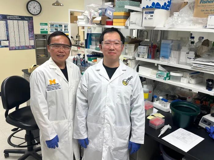 Two men in white lab coats standing in a research lab